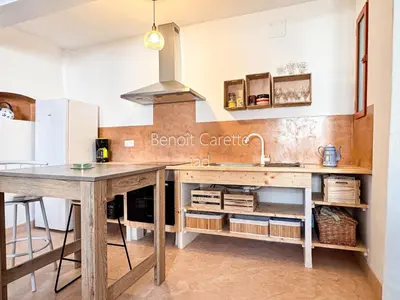a kitchen with a wooden table and a sink at La Maison Ocre in Mirepeisset