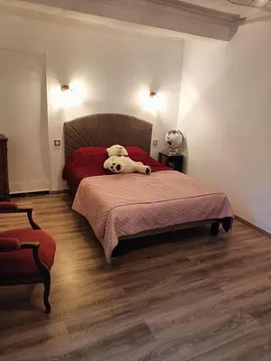 a bedroom with a bed with a red bedspread and two lights at La Maison Ocre in Mirepeisset