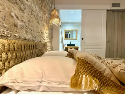 a bedroom with a bed and a stone wall at 43 Belle vue - Luxury in Carcassonne