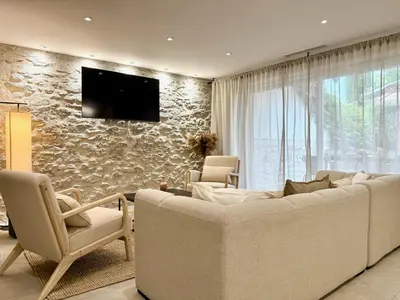 a living room with a couch and a tv on a stone wall at 43 Belle vue - Luxury in Carcassonne