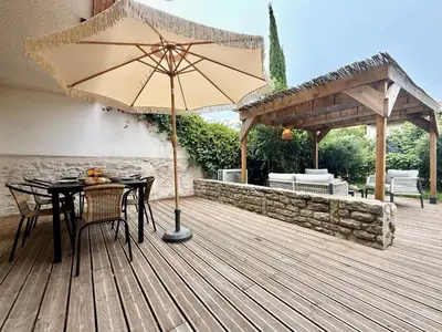 a wooden deck with a table and an umbrella at 43 Belle vue - Luxury in Carcassonne