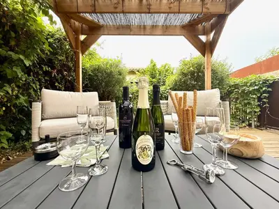 a wooden table with wine bottles and glasses on it at 43 Belle vue - Luxury in Carcassonne