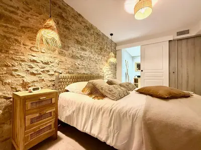 a bedroom with a bed and a stone wall at 43 Belle vue - Luxury in Carcassonne