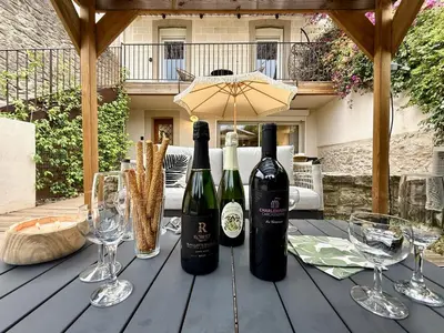 three bottles of wine on a wooden table with wine glasses at 43 Belle vue - Luxury in Carcassonne