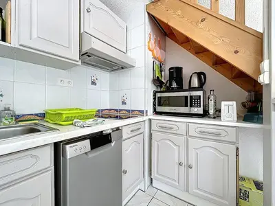a white kitchen with a sink and a microwave at La Feuilleraie - Maison de vacance à Leucate in Leucate