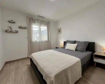 a bedroom with a large bed and a window at Chez Nous, Chez Vous ! in La Redorte