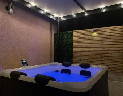 a bath room with a tub with chairs in it at Chez Nous, Chez Vous ! in La Redorte