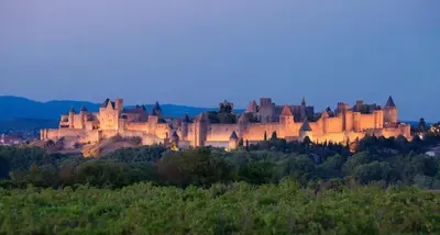 a castle sitting on top of a hill at dusk at Chez Nous, Chez Vous ! in La Redorte