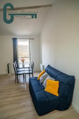 a living room with a blue couch and a table at Cœur de ville studio lumineux in Castelnaudary