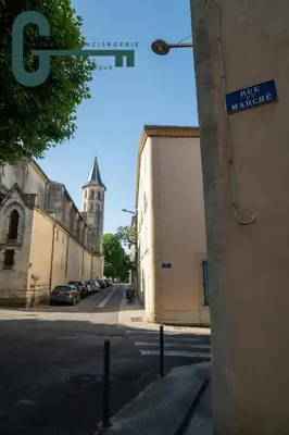 a street sign on the side of a building with a church at Cœur de ville studio lumineux in Castelnaudary