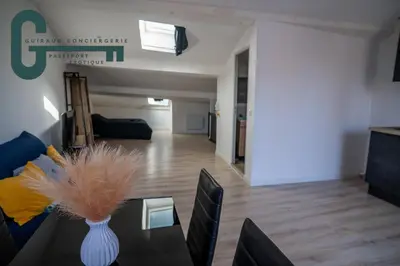 a living room with a vase on a table at Cœur de ville studio lumineux in Castelnaudary