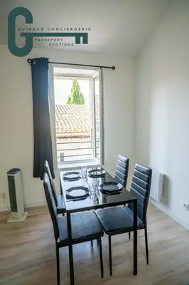 a dining room with a table and chairs and a window at Cœur de ville studio lumineux in Castelnaudary