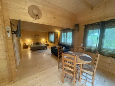 a living room with a bed and a table at Chalet Chêne-Pin in Boutenac