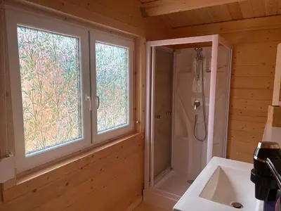 a bathroom with a shower and a sink and a window at Chalet Chêne-Pin in Boutenac