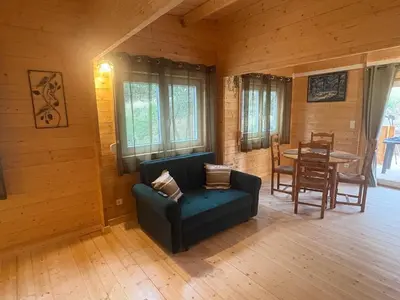 a living room with a couch and a table at Chalet Chêne-Pin in Boutenac