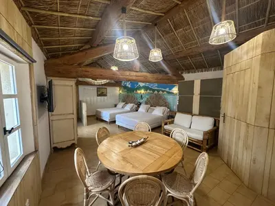 a room with a table and chairs and a couch at Studio Tahiti du Cloitre in Narbonne