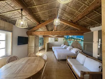 a large room with two beds and a table at Studio Tahiti du Cloitre in Narbonne