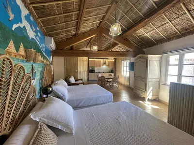 a bedroom with two beds and a living room at Studio Tahiti du Cloitre in Narbonne