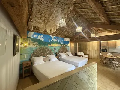 two beds in a room with a painting on the wall at Studio Tahiti du Cloitre in Narbonne