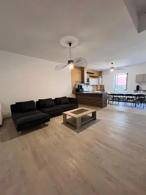 a living room with a black couch and a table at Quiet house for 12 people near Cité Carcassonne in Carcassonne