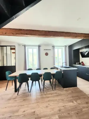 a kitchen with a table and chairs in a room at Grand T4 lumineux 200 m du port in Castelnaudary