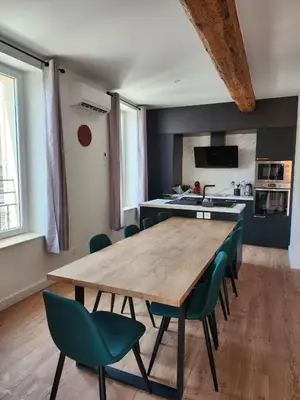 a kitchen with a wooden table and green chairs at Grand T4 lumineux 200 m du port in Castelnaudary
