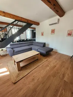 a living room with a blue couch and a coffee table at Grand T4 lumineux 200 m du port in Castelnaudary