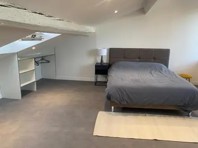a bedroom with a large bed and a rug at Superbe Appartement Atypique Combles - Neuf avec Vue in Narbonne
