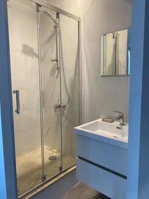 a bathroom with a glass shower and a sink at Superbe Appartement Atypique Combles - Neuf avec Vue in Narbonne