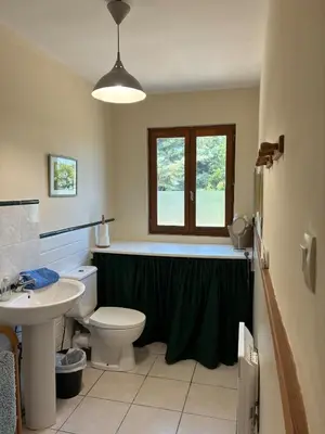 a bathroom with a toilet and a sink and a window at Vacation home with pool in Quillan