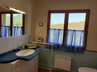 a bathroom with a sink and a large window at Vacation home with pool in Quillan