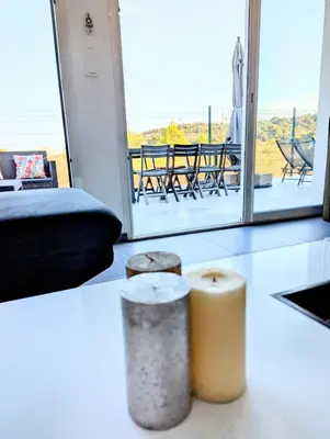 a living room with two stools and a view of a patio at Évasion à la Villa Sérénité, nature et confort in Port-la-Nouvelle