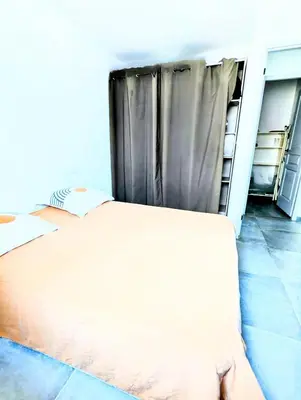 a bedroom with a bed and a curtain at Évasion à la Villa Sérénité, nature et confort in Port-la-Nouvelle