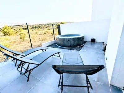 a patio with two chairs and a fire pit at Évasion à la Villa Sérénité, nature et confort in Port-la-Nouvelle