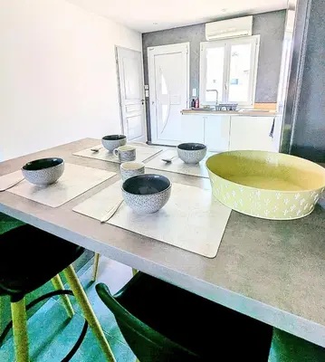 a kitchen with a table with bowls on it at Évasion à la Villa Sérénité, nature et confort in Port-la-Nouvelle