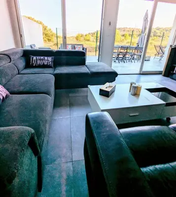 a living room with two couches and a table at Évasion à la Villa Sérénité, nature et confort in Port-la-Nouvelle