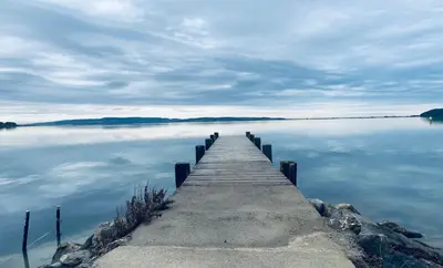 a dock on a lake with a cloudy at Grain de sel in Sigean