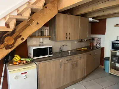 a kitchen with wooden cabinets and a bowl of fruit at Grain de sel in Sigean