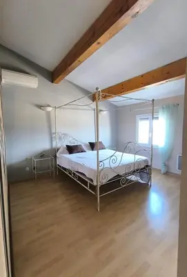 a bedroom with a canopy bed and a wooden floor at Agréable maison avec jacuzzi in Vinassan