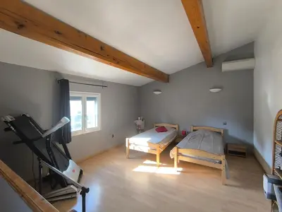 a room with a bed and a treadmill in it at Agréable maison avec jacuzzi in Vinassan