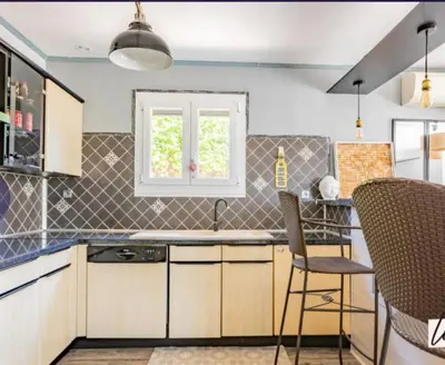a kitchen with a sink and two chairs in it at Agréable maison avec jacuzzi in Vinassan