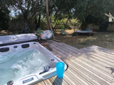 a hot tub sitting on a wooden deck at Agréable maison avec jacuzzi in Vinassan