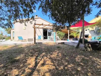 a house with a large yard with a tree at Agréable maison avec jacuzzi in Vinassan