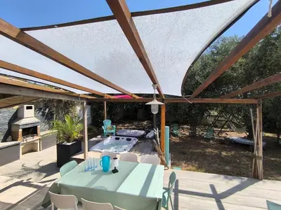 a patio with a table and a swimming pool at Agréable maison avec jacuzzi in Vinassan