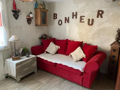 a red couch in a room with a sign on the wall at Hameau le Caunil in Salvezines