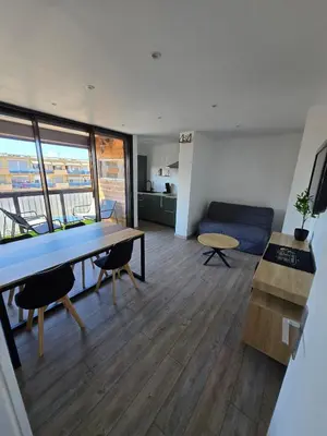 a living room with a table and a couch at Sejour plage Port-la-Nouvelle in Port-la-Nouvelle
