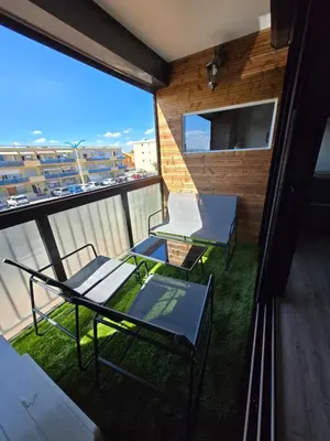 two chairs and tables on a balcony with a view at Sejour plage Port-la-Nouvelle in Port-la-Nouvelle