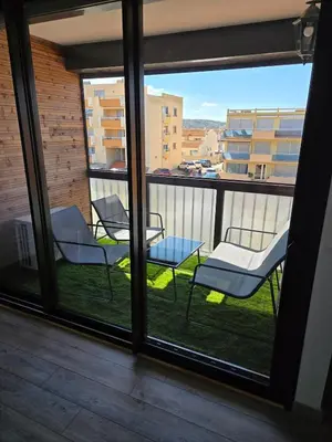 a balcony with chairs and a view of a city at Sejour plage Port-la-Nouvelle in Port-la-Nouvelle