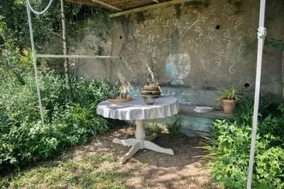 a white table in a garden with plants at BB Villa Sainte Marie in Limoux