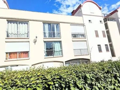 a white building with windows and a hedge at Cocoon sur le port de Gruissan, parking & piscine in Gruissan